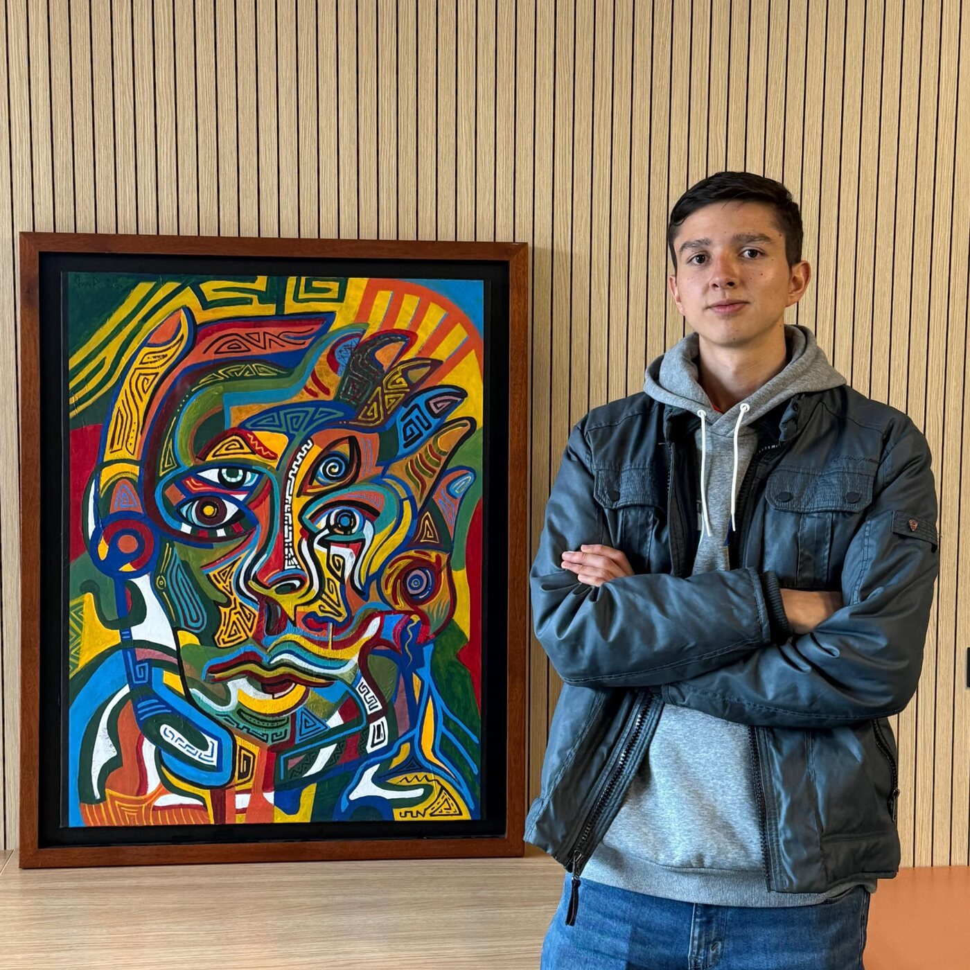 Juan Felipe Ruge beside his painting Enough